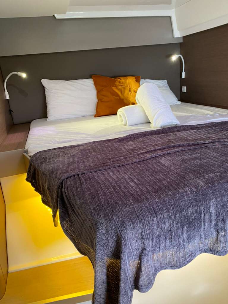 Bali Catspace master bed close-up with purple throw and ambient lighting