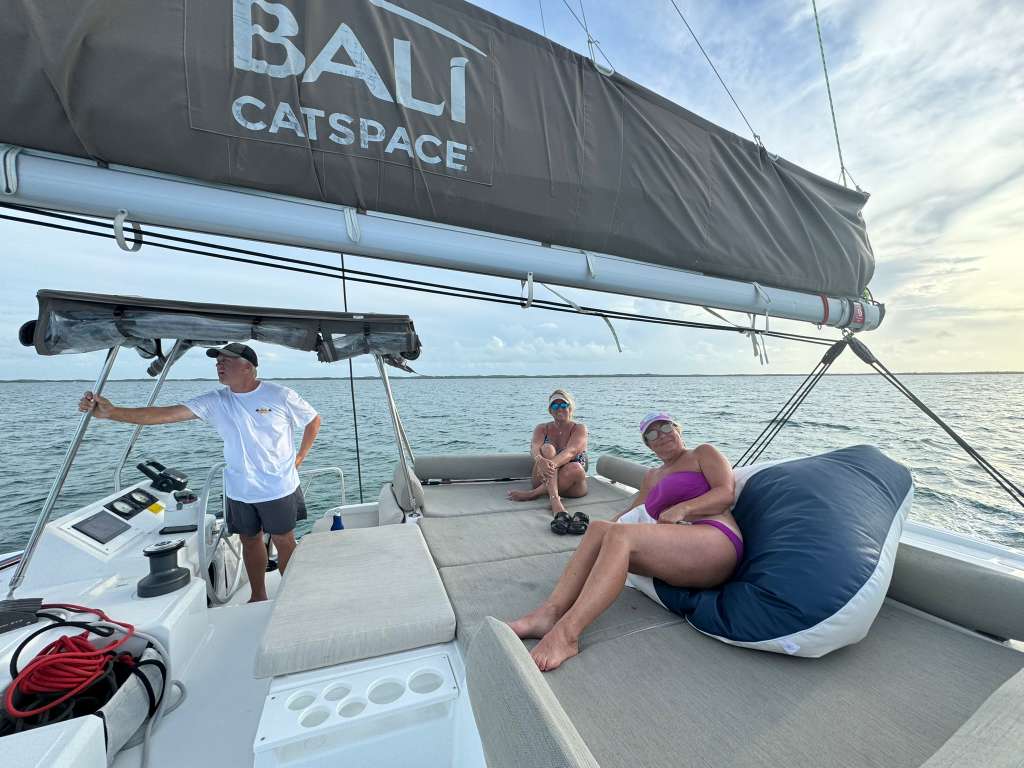 Guests lounging on Bali Catspace flybridge at sunset golden hour