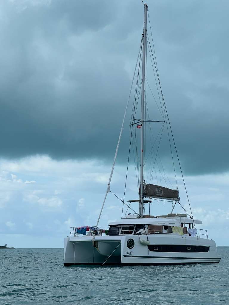 Bali Catspace catamaran at anchor with dramatic stormy sky, full profile