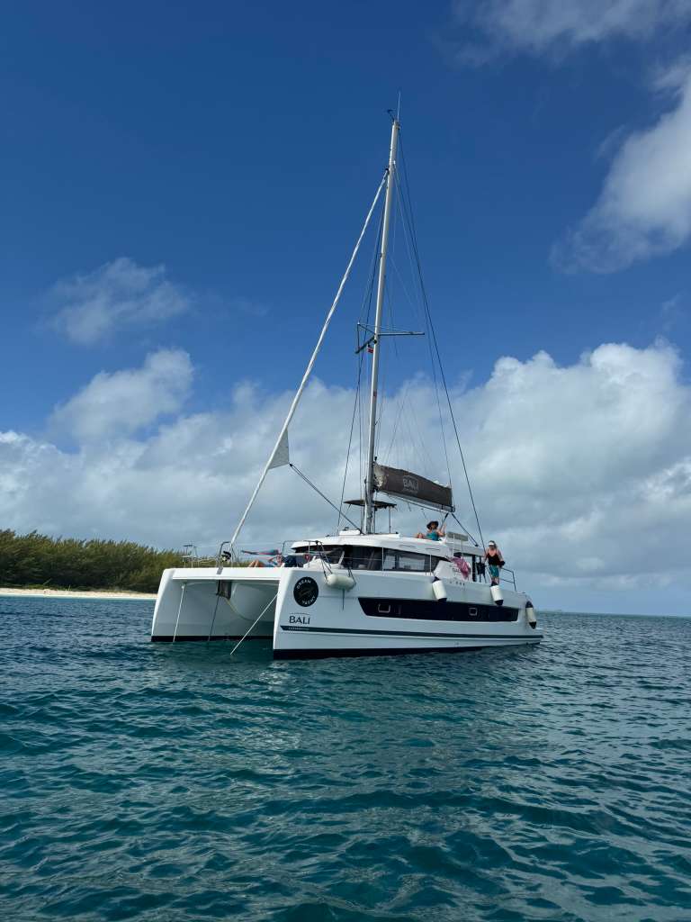 Bali Catspace catamaran anchored in tropical turquoise water near beach