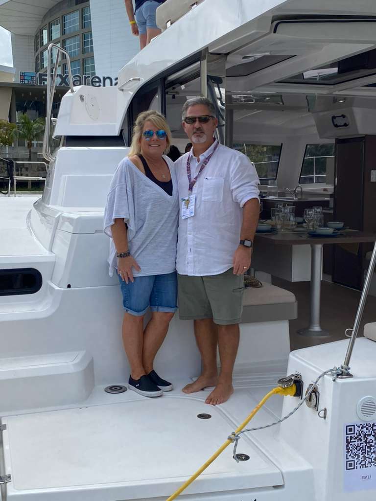Couple posing on stern of Bali Catspace catamaran at boat show