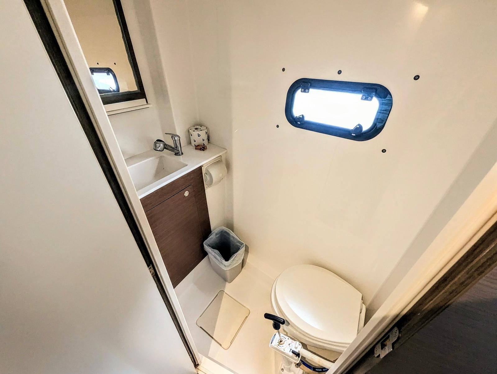 Yacht head bathroom with shower and porthole