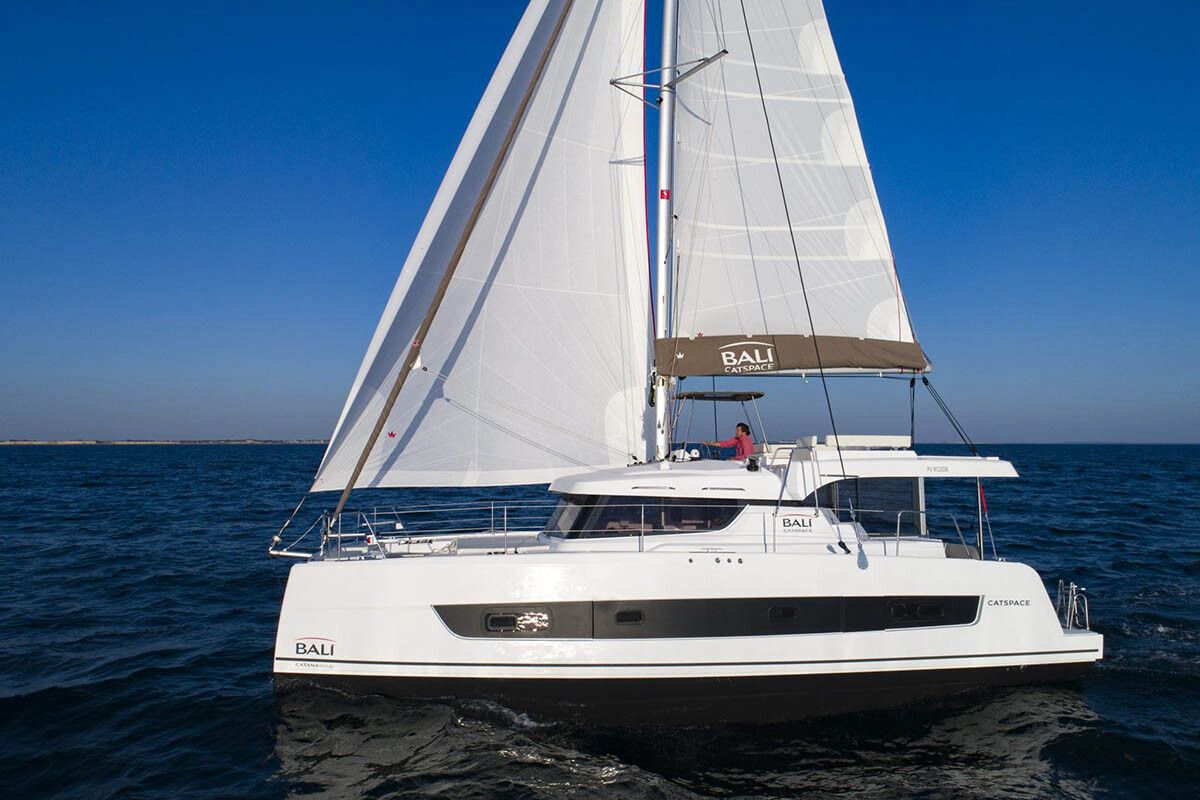 Bali Catspace sailing side profile with sails up against blue sky
